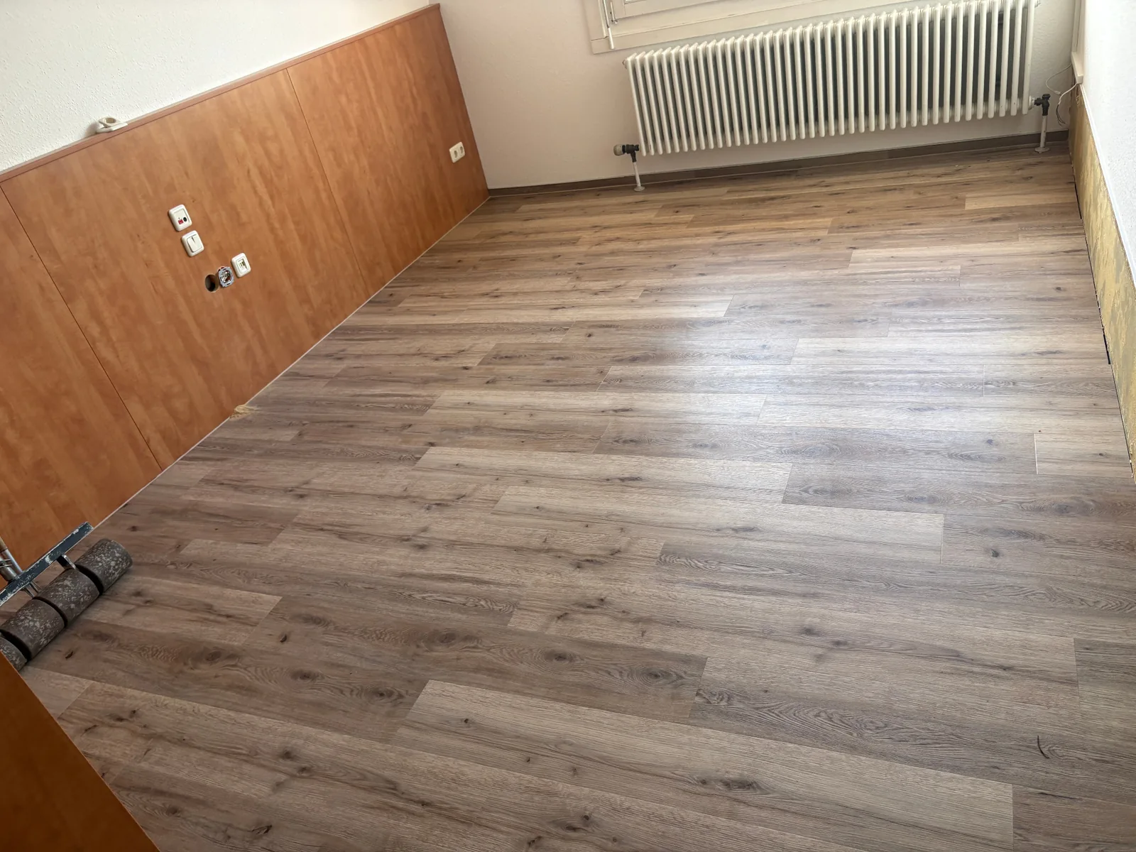 Frisch verlegter Boden in einem Raum mit Holzverkleidung