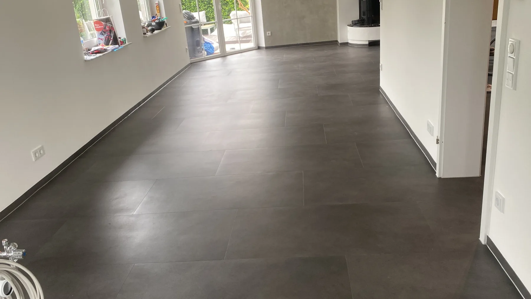 Großformatiger dunkler Bodenbelag in einem Wohnbereich